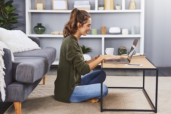 Woman Working on Her Laptop Sitting on the Floor