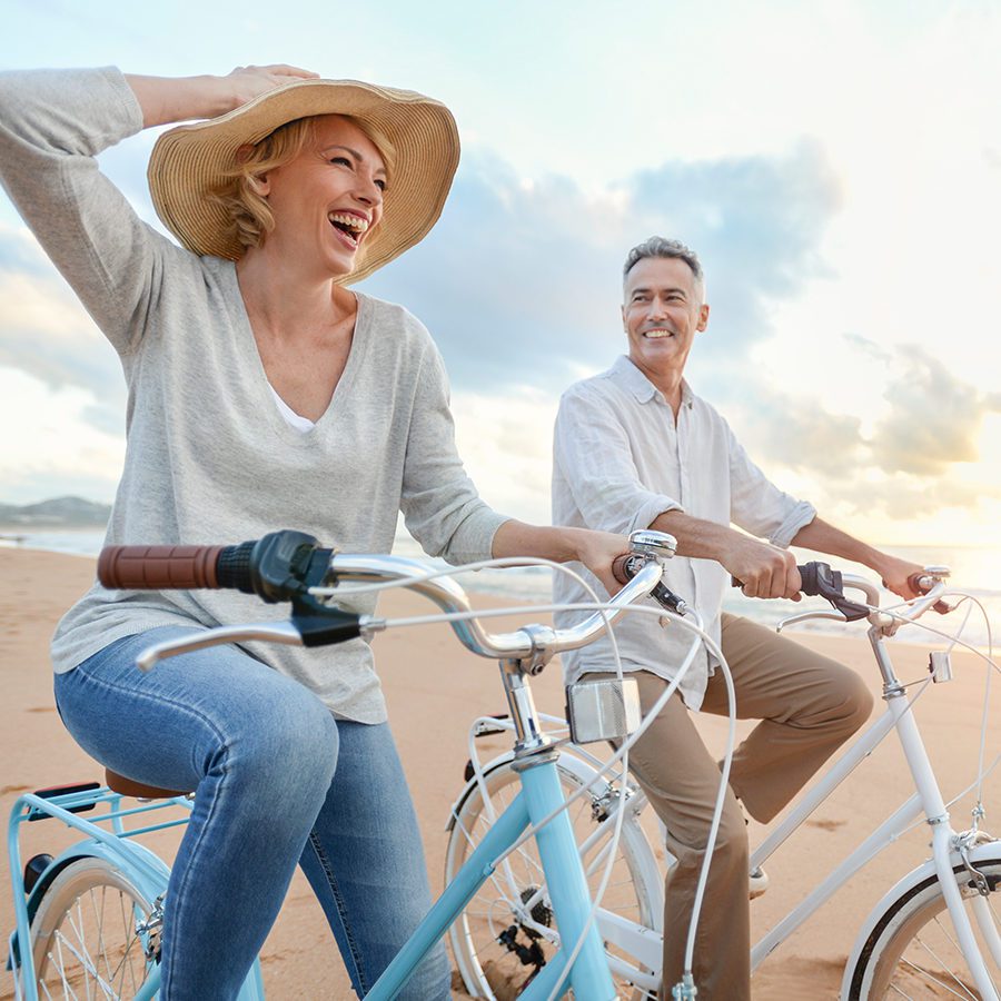 Older Couple Enjoying a Bike Ride on the Beach