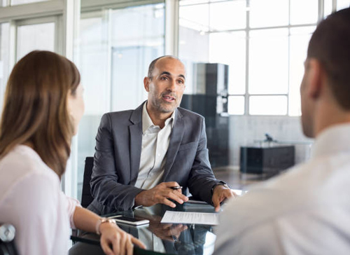 Man speaking to a man and a woman in an office setting, The Federal Savings Bank