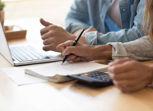 People writing on documents with a pen