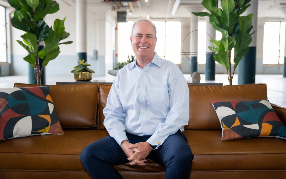 John Calk, CEO of The Federal Savings Bank sitting on a brown sofa