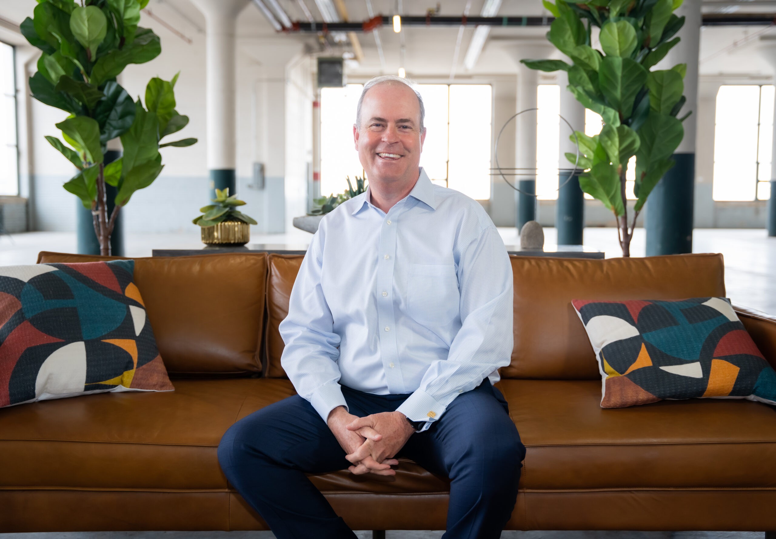 John Calk, CEO of The Federal Savings Bank sitting on a brown sofa