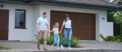 Couple holding hands with child outside new home