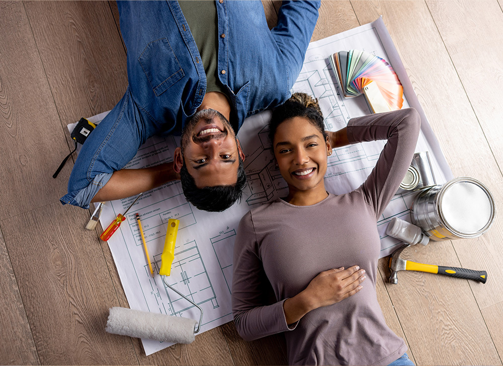a man and a woman laying on the floor face up on top of paperwork
