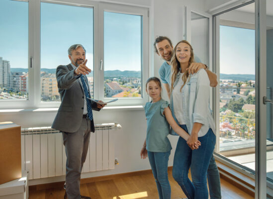 Realtor showing a young happy family a home for sale.