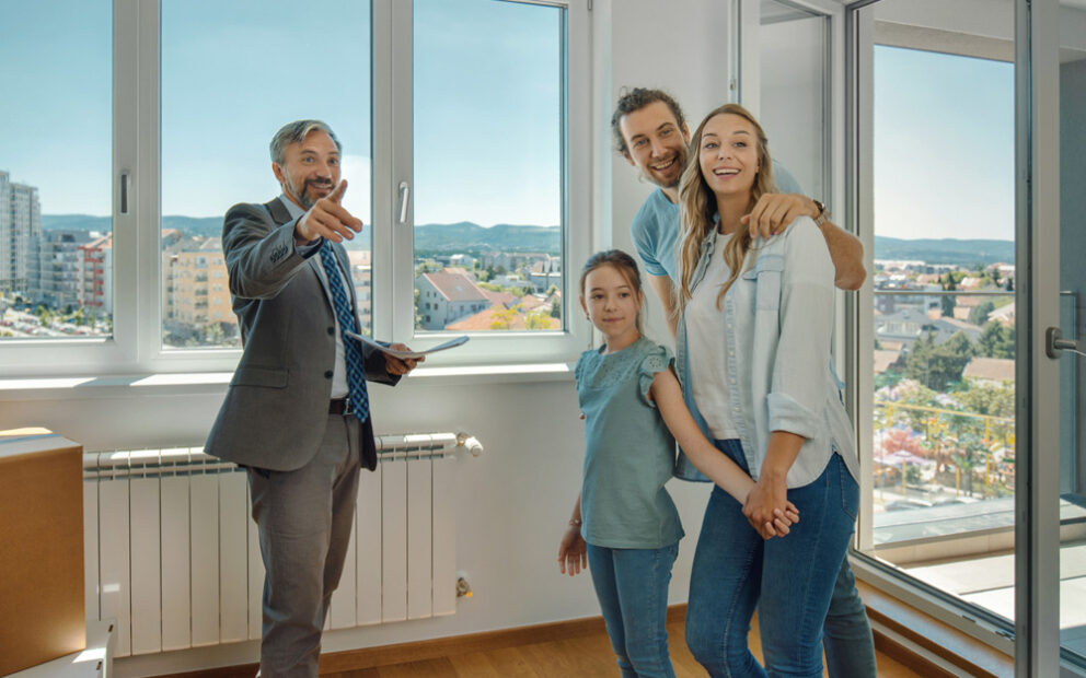 Realtor showing a young happy family a home for sale.