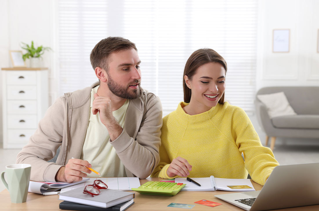 Couple looking at computer, working through their finances.