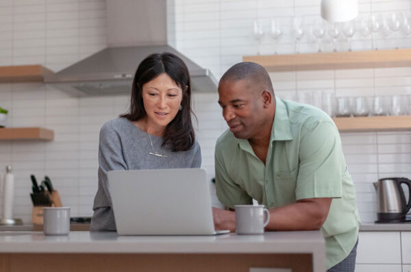 Couple looking at computer in a modern kitchen
