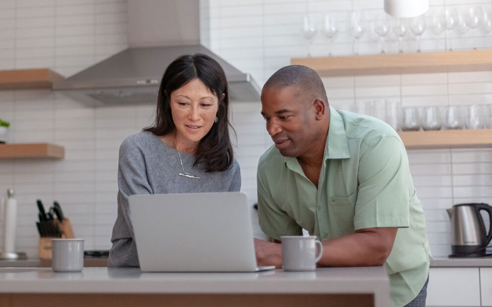 Couple looking at computer in a modern kitchen