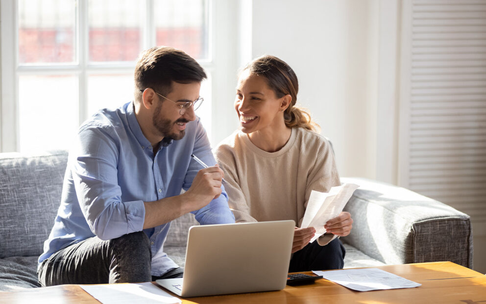 Couple reviewing documents and working at computer