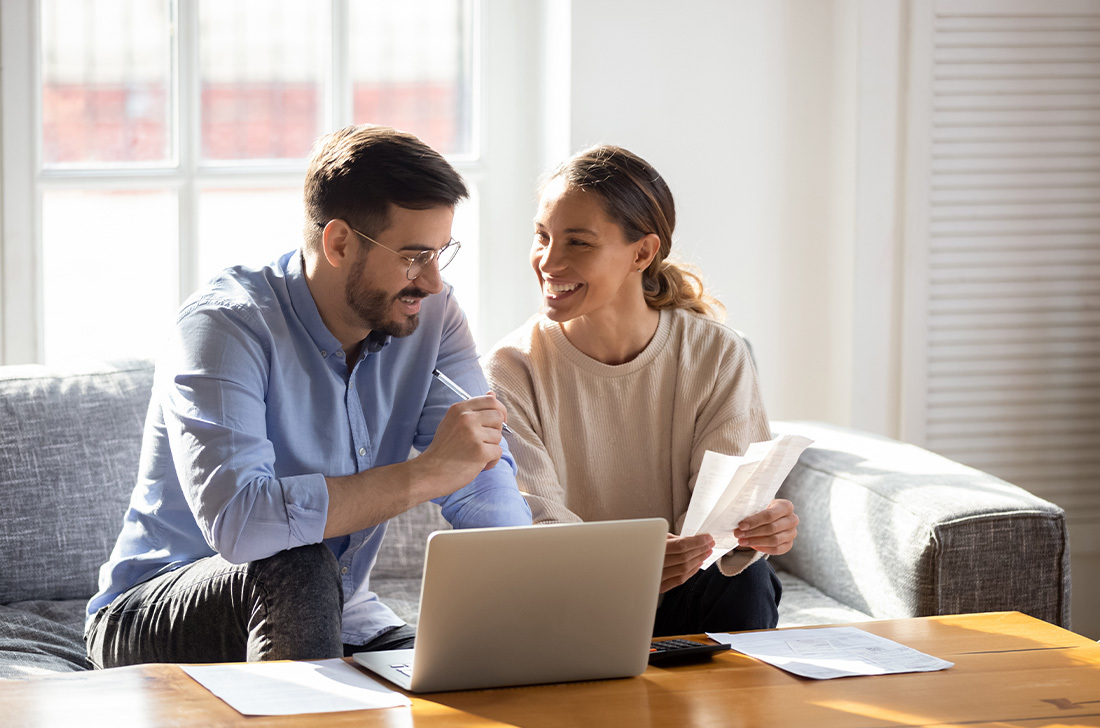 Couple reviewing documents and working at computer