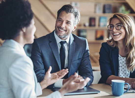 Couple in a meeting, smiling and talking with a business woman.