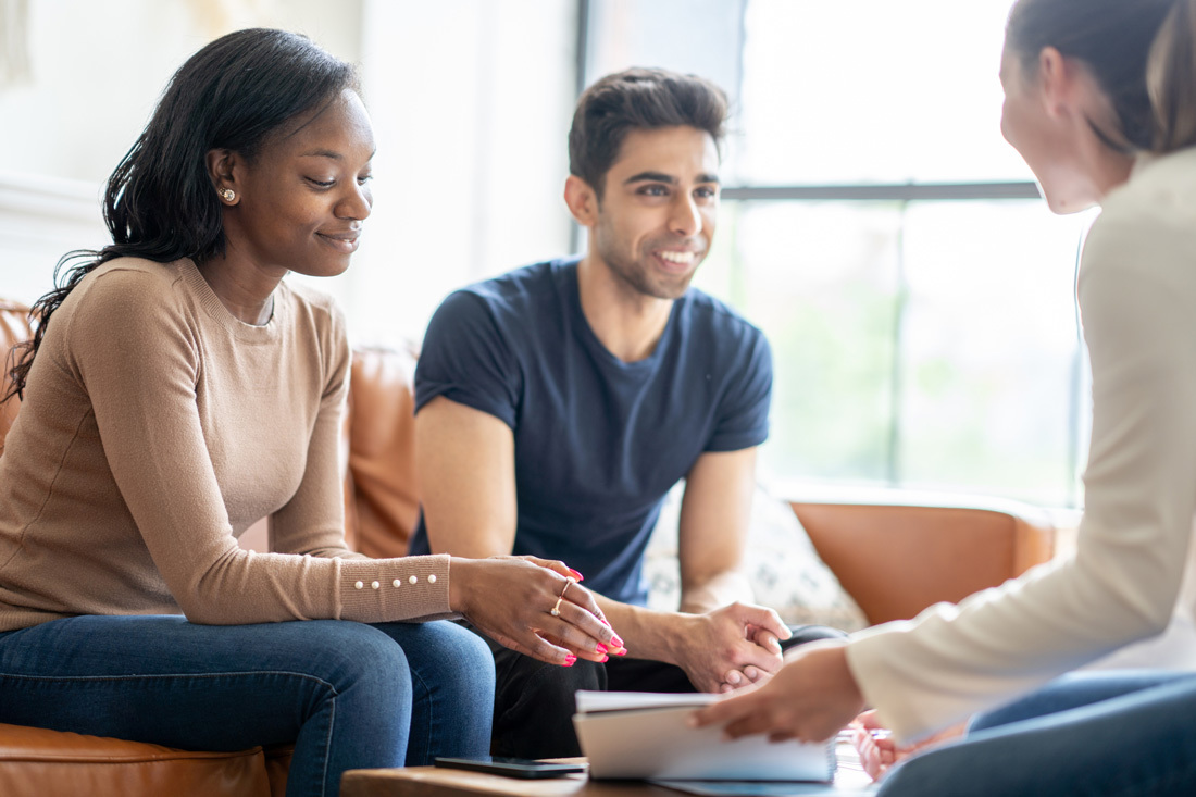 Young couple discussing with a financial professional.