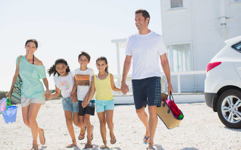 Young family enjoying their day on the beach next to their vacation home.