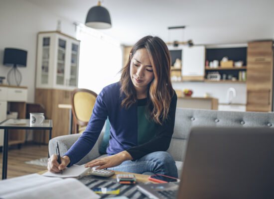 Young woman working on her finances in her living room