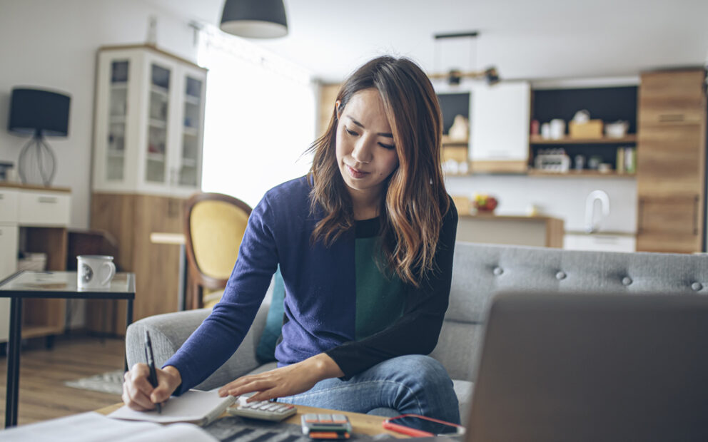 Young woman working on her finances in her living room