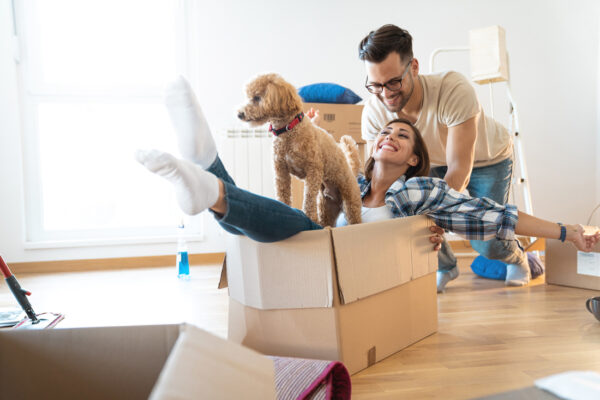 Happy couple moving into new home with their puppy.