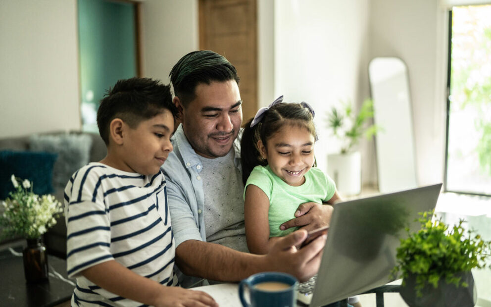 Young Latino family looking at a computer together.
