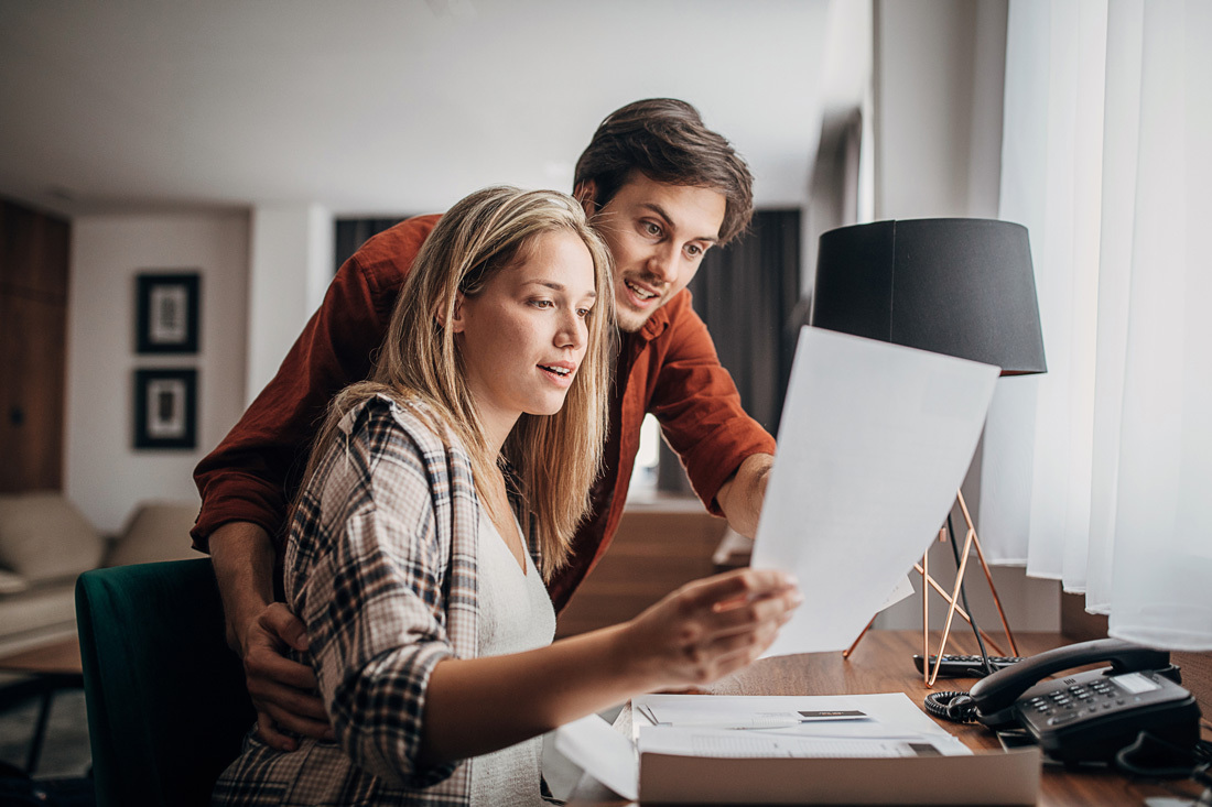 Young couple reviewing documentation at a desk.