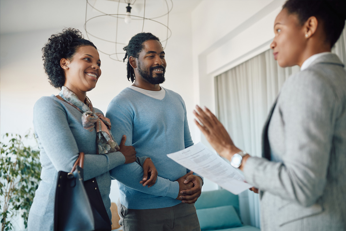 Couple discussing with a businesswoman.