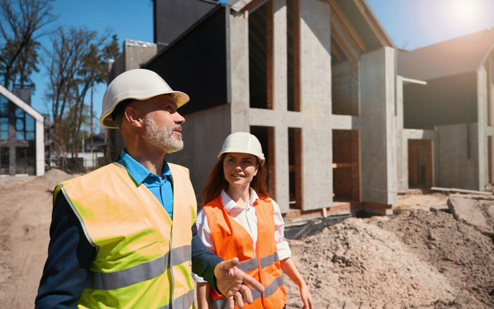 Construction worker showing owner the construction site of her future home.