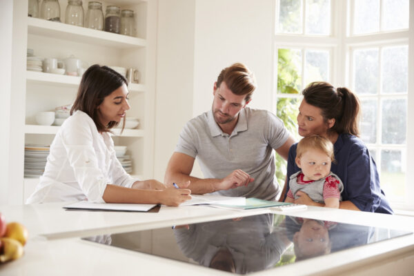 Couple and their baby looking over documents with an advisor