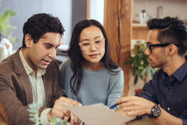 Couple sitting down reviewing documents with an advisor