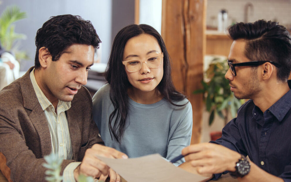 Couple sitting down reviewing documents with an advisor