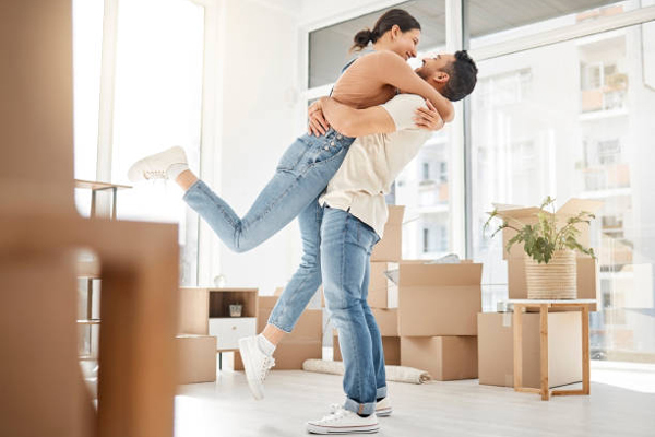 Guy lifting woman up in celebratory hug in new home