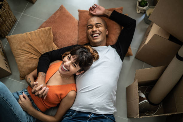 Man and woman laying together on the floor while laughing