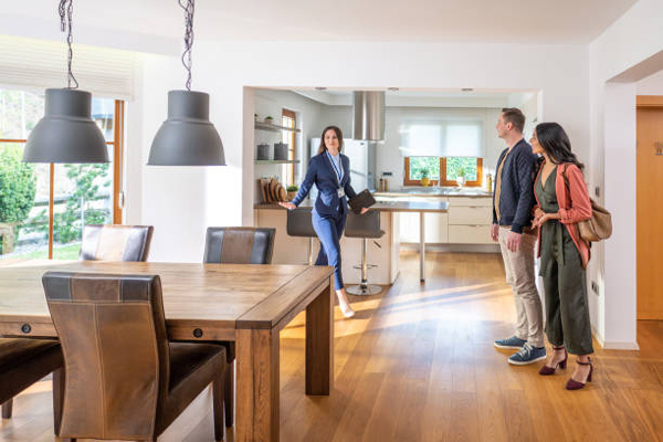 Woman realtor showing couple inside of a house