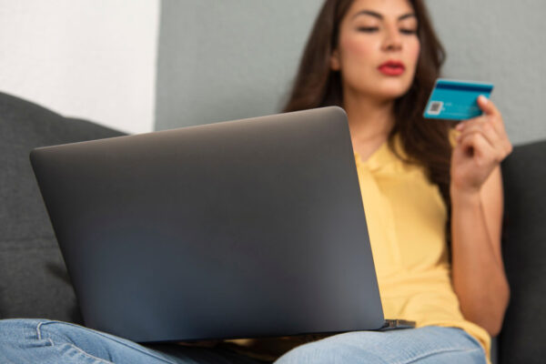 Woman using credit card on laptop