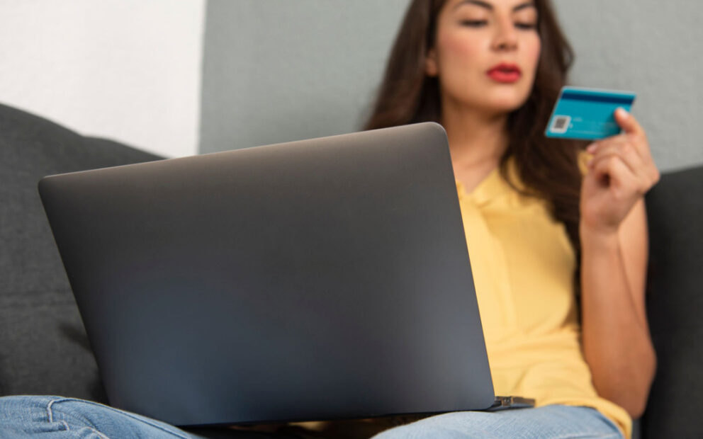 Woman using credit card on laptop