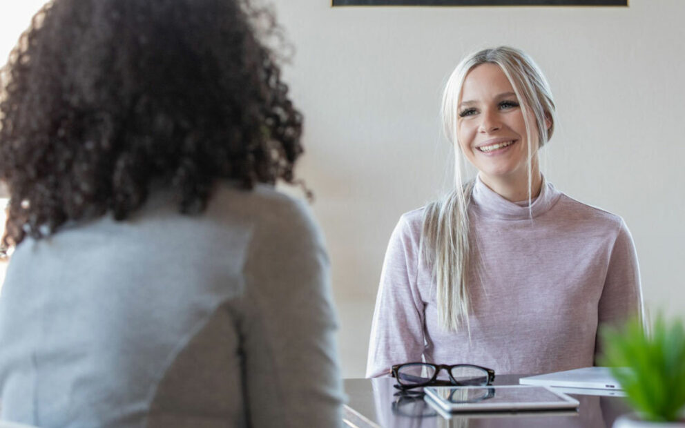 Two women discussing at a kitchen table