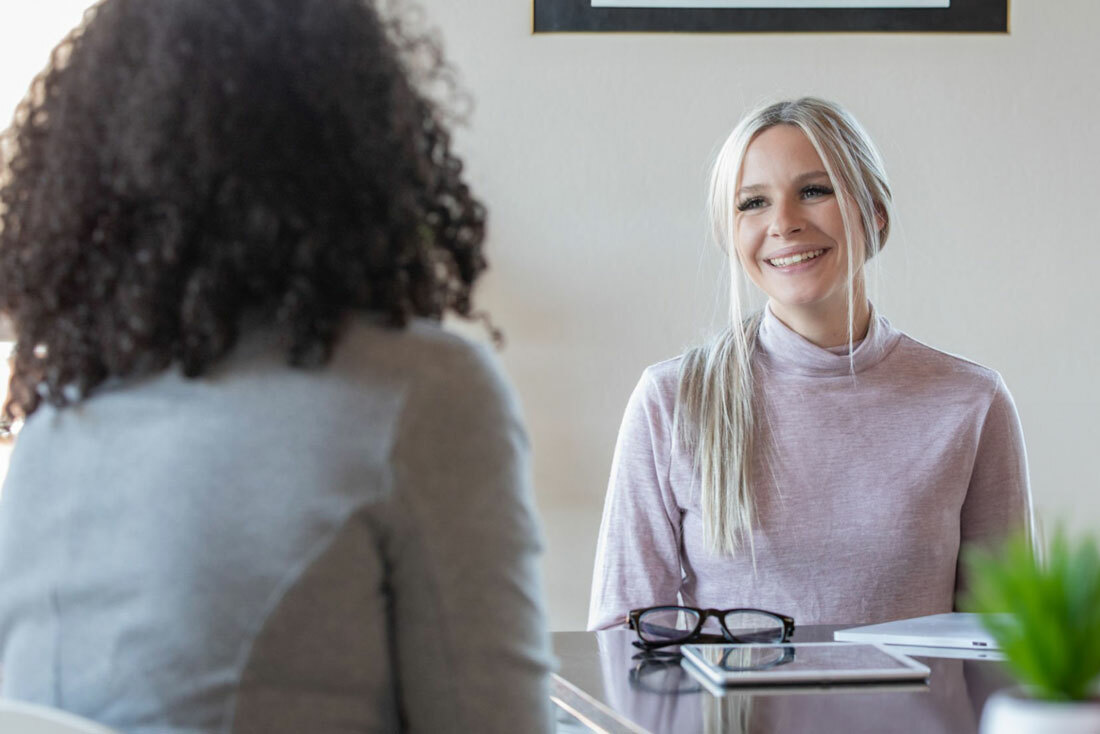 Two women discussing at a kitchen table