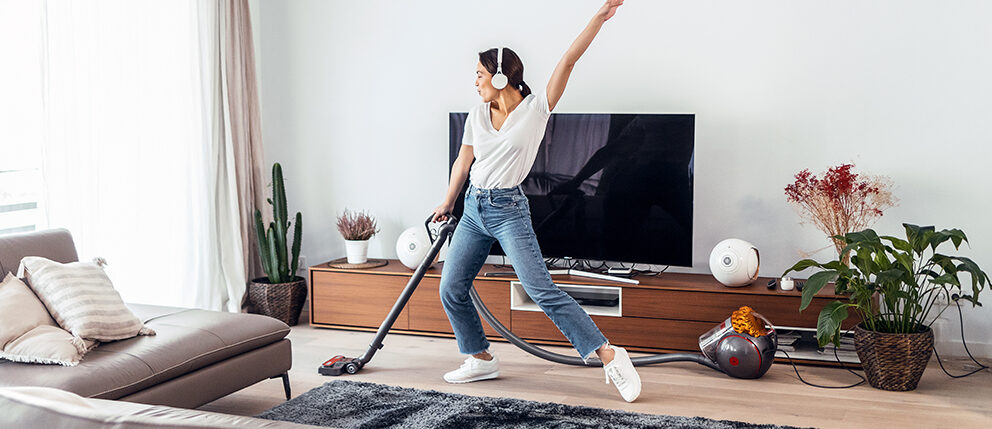 Woman having fun while she vacuuming her living room