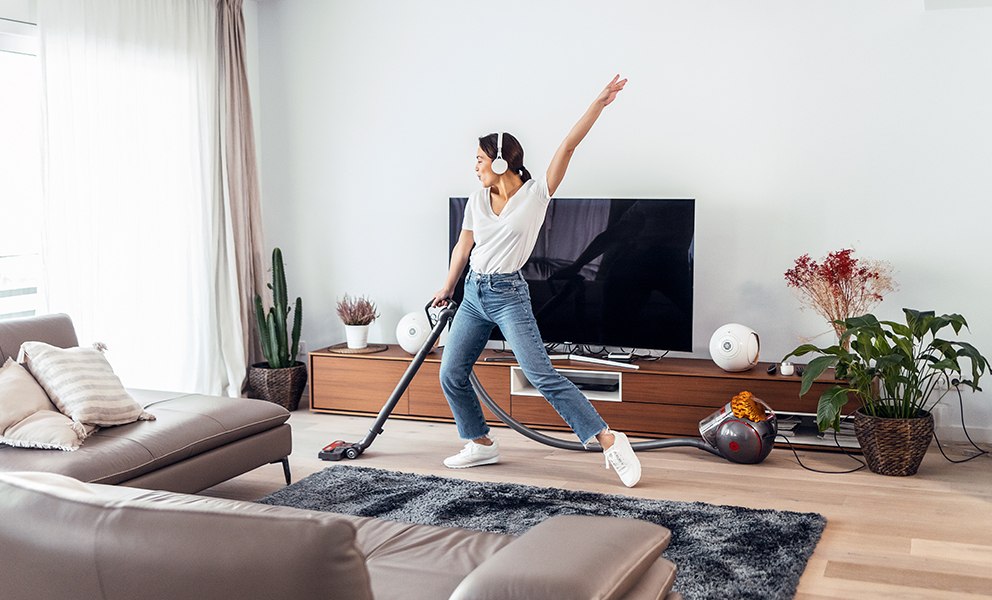 Woman having fun while she vacuuming her living room