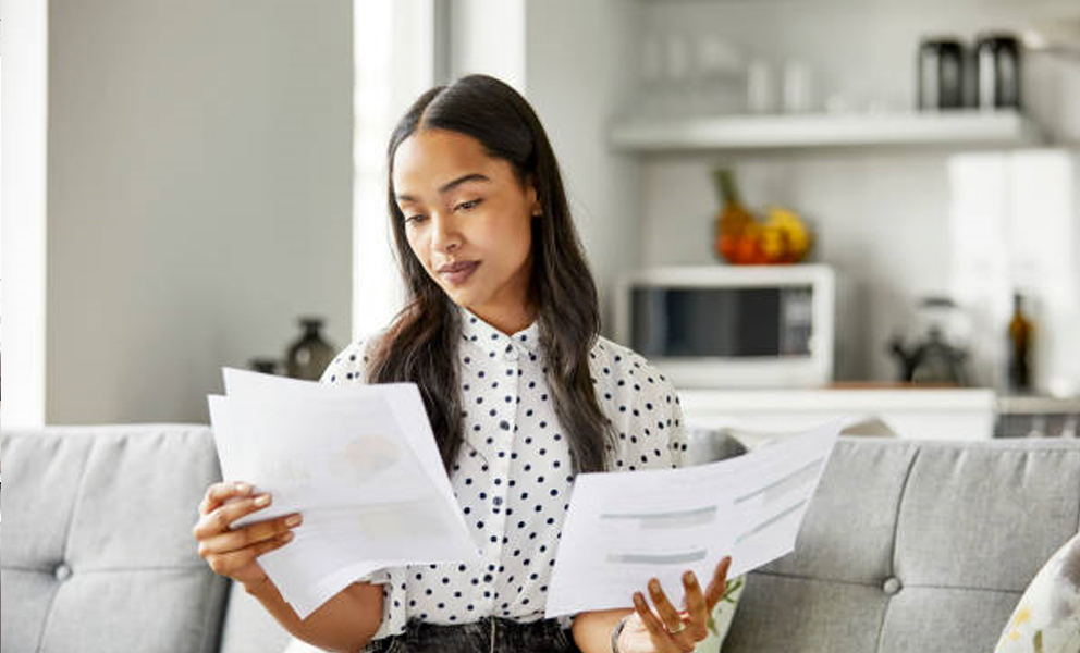 Woman comparing documents in her living room
