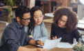 Man and woman couple reviewing documents with advisor