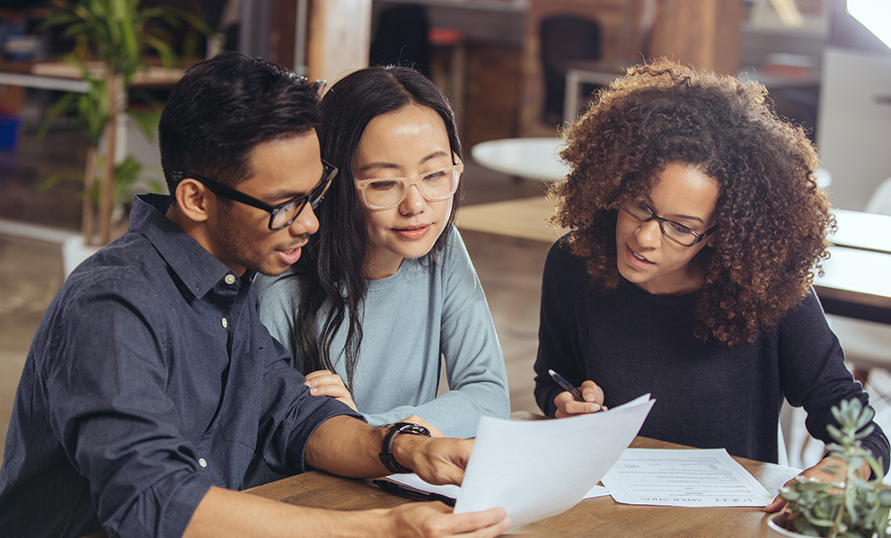 Man and woman couple reviewing documents with advisor