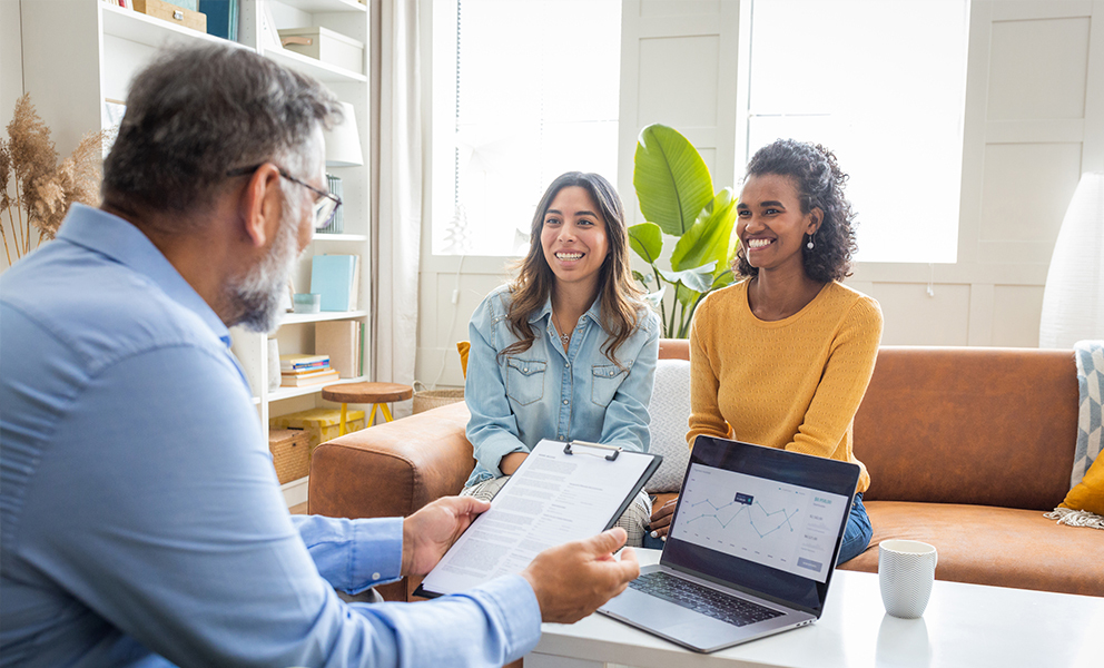 Couple happily discussing details with loan officer