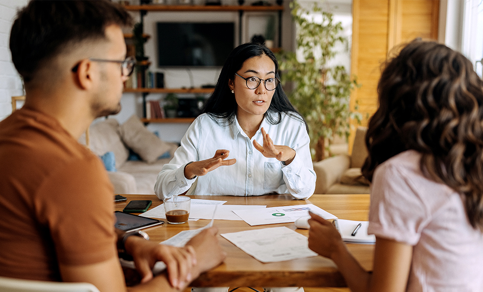 Woman professional explaining documents to couple at table