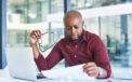 Man sitting at table while reviewing finance documents