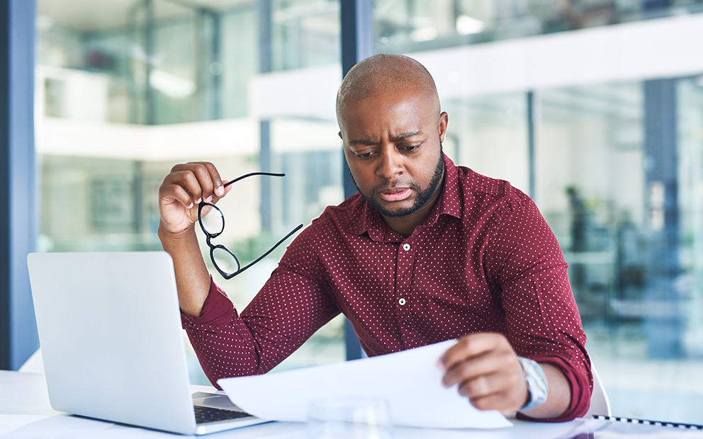 Man sitting at table while reviewing finance documents