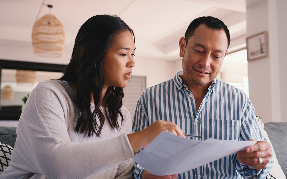 Couple sitting together while looking over documents