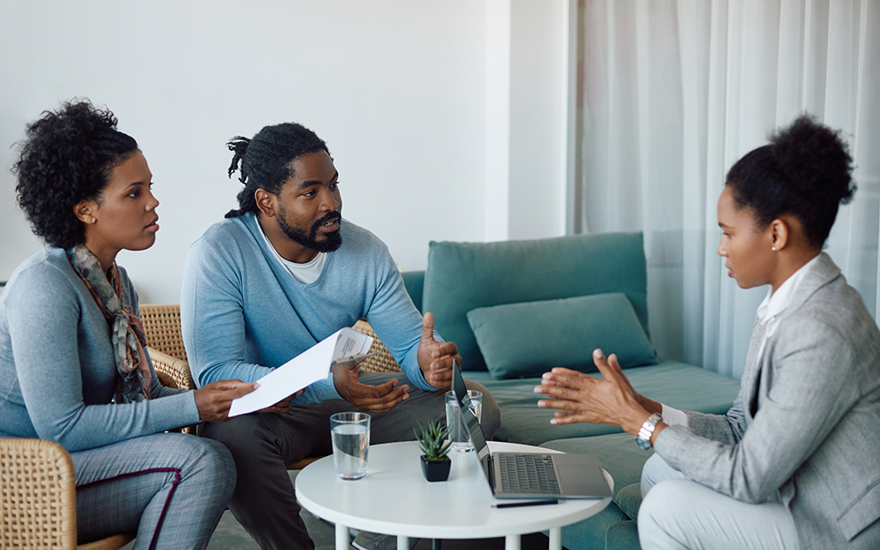 Couple sitting down and speaking with lender