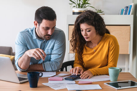 Couple sitting together while they review financial documents