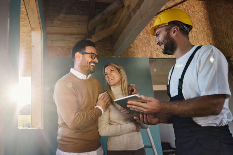 Couple speaking with builder inside home