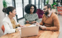 Man and woman couple speaking with advisor while sitting at a table