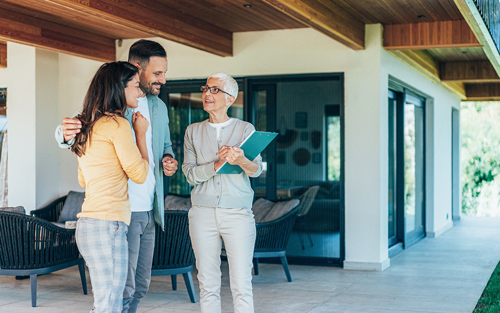 Couple outside home meeting and talking with realtor